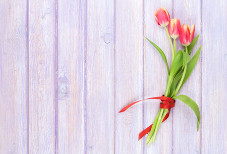 Colorful tulips on wooden table. Top view with copy spaceの写真素材