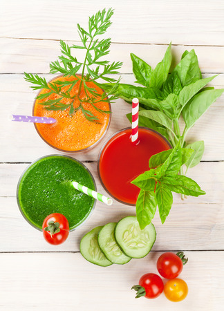 Fresh vegetable smoothie on wooden table. Tomato, cucumber, carrot. Top viewの写真素材