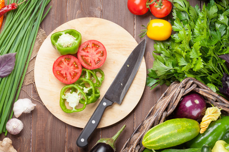 Fresh farmers garden vegetables and herbs cooking on wooden table. Top view
