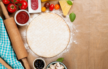 Pizza cooking ingredients. Dough, vegetables and spices. Top view with copy spaceの写真素材