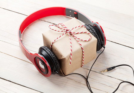 Gift box with headphones on wooden tableの写真素材