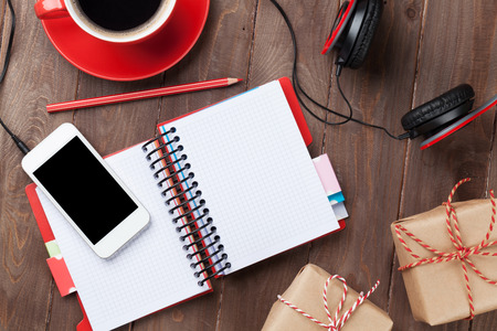 Office wooden desk with notepad, smartphone and gift boxes. Top view with copy spaceの写真素材