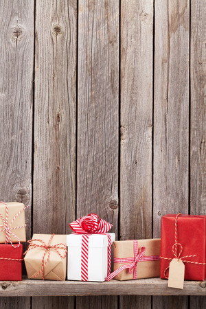 Christmas gift boxes in front of wooden wall. View with copy spaceの写真素材