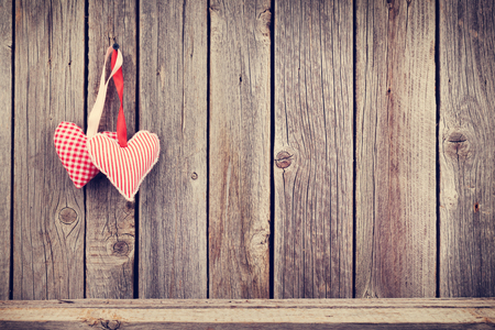 Two Valentines day hearts on rustic wooden wall with copy space. Tonedの写真素材