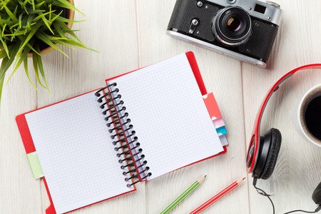 Set of travel stuff. Camera, headphones, notepad and coffee cup on wooden table. Top view with copy spaceの写真素材