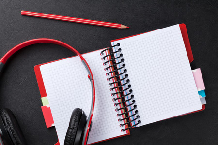 Office leather desk with notepad and headphones. Top view with copy spaceの写真素材