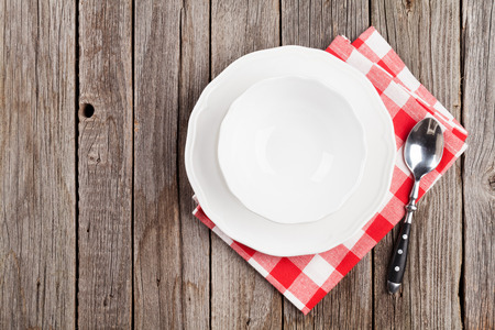 Empty plate, bowl and spoonon wooden table. Top view with copy spaceの写真素材