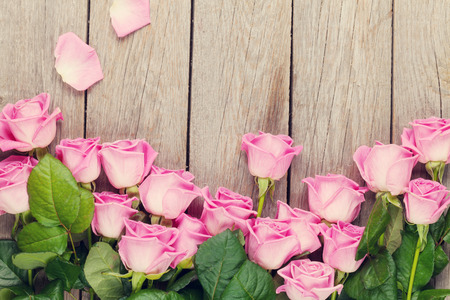 Pink roses bouquet over wooden table. Top view with copy space. Tonedの写真素材