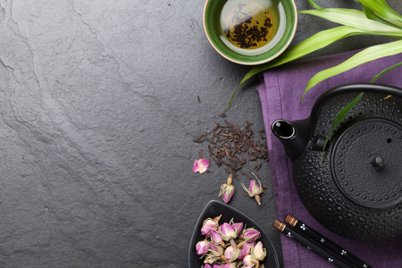 Asian sushi chopsticks, rose tea and teapot over stone table. Top view with copy spaceの写真素材