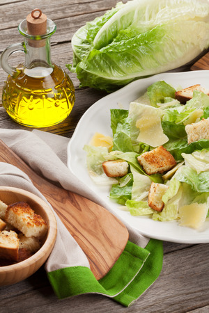 Fresh healthy caesar salad cooking on wooden tableの写真素材
