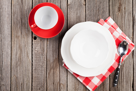 Empty plate, cup and spoon on wooden table. Top view with copy spaceの写真素材