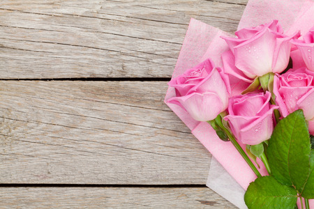 Garden pink roses bouquet over wooden table. Top view with copy spaceの写真素材