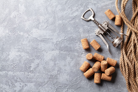 Wine corks and corkscrew over stone background. Top view with copy spaceの写真素材