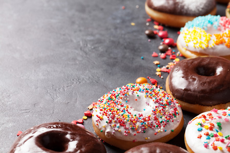 Colorful donuts on stone table. View with copy spaceの写真素材