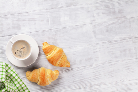 Fresh croissants and coffee on wooden table. Top view with copy spaceの写真素材