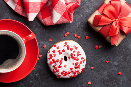 Donut, coffee and gift box on stone table. Top viewの写真素材