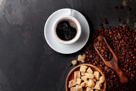 Coffee cup, beans and brown sugar on stone table. Top view with copy spaceの写真素材