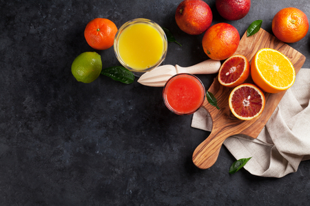 Fresh citruses and juice on dark stone background. Oranges and limes. Top view with copy spaceの写真素材