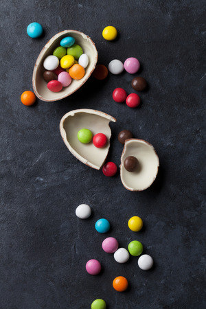 Colorful candies and chocolate egg on stone background. Top viewの写真素材