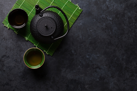 Green tea cups and teapot on stone table. Top view with copy spaceの写真素材