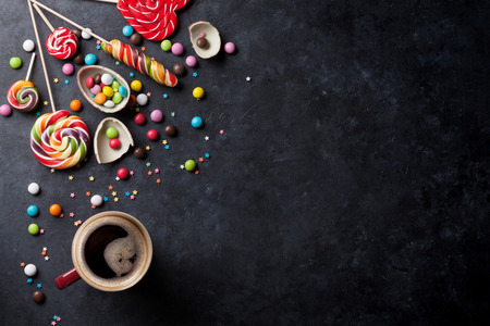 Colorful candies and coffee cup on stone background. Top view with copy spaceの写真素材