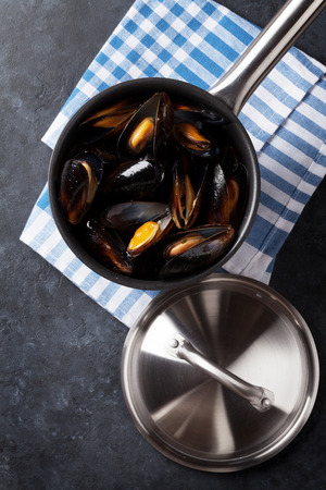 Mussels in copper pot on stone table. Top viewの写真素材