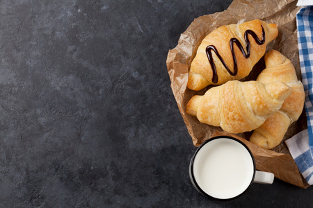 Fresh croissants and milk on stone table. Top view with copy spaceの写真素材