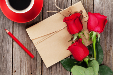 Love letter and red roses on wooden table.の写真素材