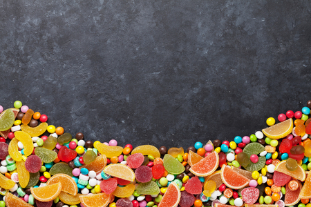 Colorful candies, jelly and marmalade over stone background. Top view with copy spaceの写真素材