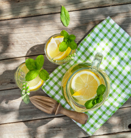 Lemonade with lemon, mint and ice on garden table. Top viewの写真素材