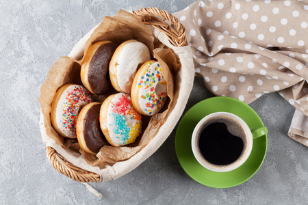 Colorful donuts and coffee cup on stone table. Top viewの写真素材
