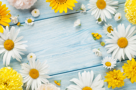 Garden flowers over blue wooden table background. Backdrop with copy spaceの写真素材