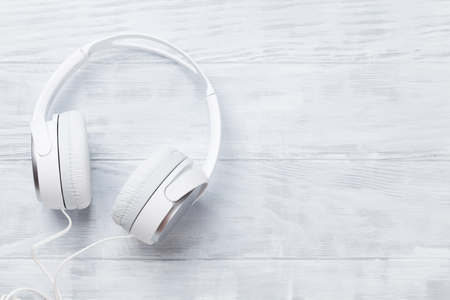 White headphones for music sound on wooden table. Top view with copy space for textの写真素材