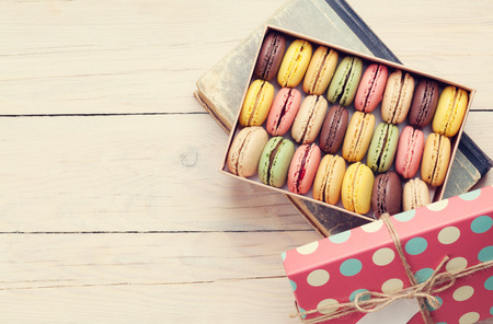 Colorful macaroons on wooden table. Top view with copy space for text. Retro tonedの写真素材