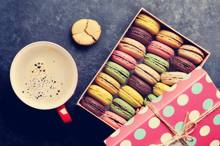 Colorful macaroons and coffee on stone table. Top view. Retro tonedの写真素材