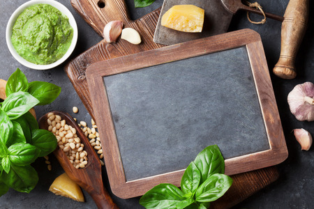 Pesto sauce cooking. Basil, olive oil, parmesan, garlic, pine nuts. Top view with chalkboard for textの写真素材