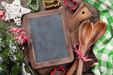 Christmas cooking utensils and snow tree on wooden table. Top view with chalk board copy space for textの写真素材