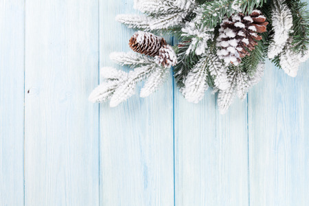 Christmas wooden background with snow fir tree and copy space