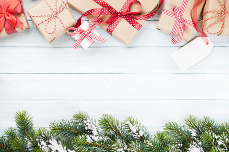 Christmas gift boxes and fir tree branch on wooden table. Top view with copy spaceの写真素材