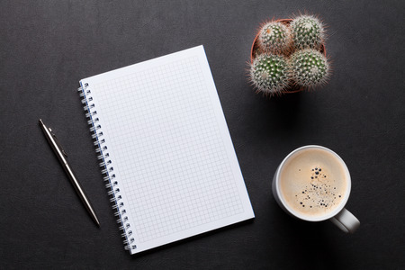 Office leather desk table with notepad, coffee, cactus and pen. Top view with copy spaceの写真素材