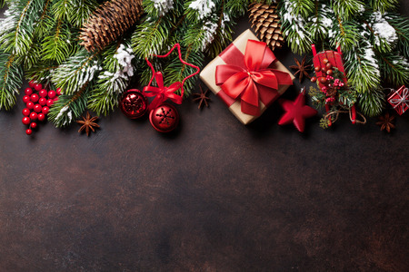 Christmas stone background with snow fir tree, gift box and decor. Top view with copy spaceの写真素材