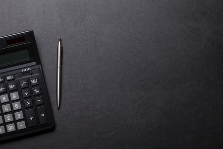 Office leather desk table with calculator and pen. Top view with copy spaceの写真素材
