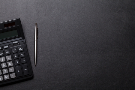 Office leather desk table with calculator and pen. Top view with copy space