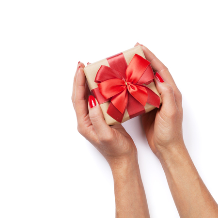 Female hands holding christmas or valentines day gift. Isolated on white background. Top viewの写真素材