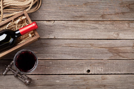 Red wine bottle and glass on wooden table. Top view with copyspaceの写真素材