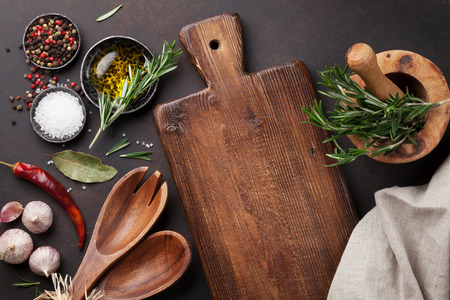 Cooking table with herbs, spices and utensils. Top view with copy space