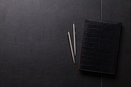 Office leather desk table with notepad, pen and pencil. Top view with copy spaceの写真素材
