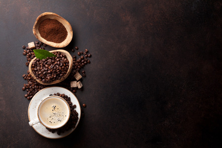 Coffee cup, beans and ground powder on stone background. Top view with copy space for your textの写真素材
