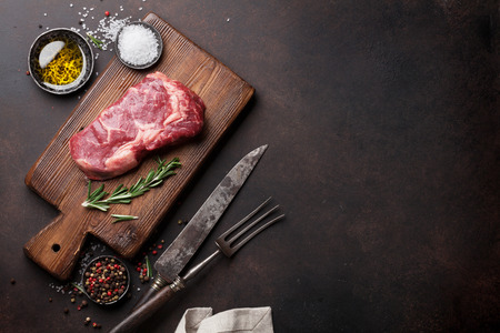 Raw ribeye beef steak cooking with ingredients. Top view with copy spaceの写真素材