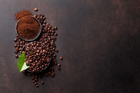 Coffee beans and ground powder on stone background. Top view with copy space for your textの写真素材